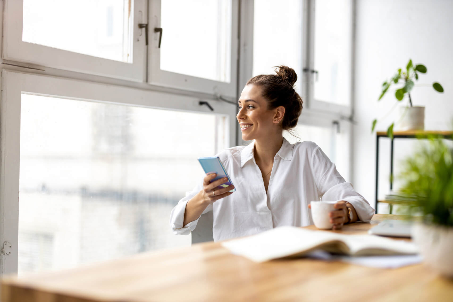 Kobieta z telefonem przy biurku — m4eGroup